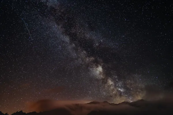 Voie lactée au-dessus d'un horizon de montagne, de nuit
